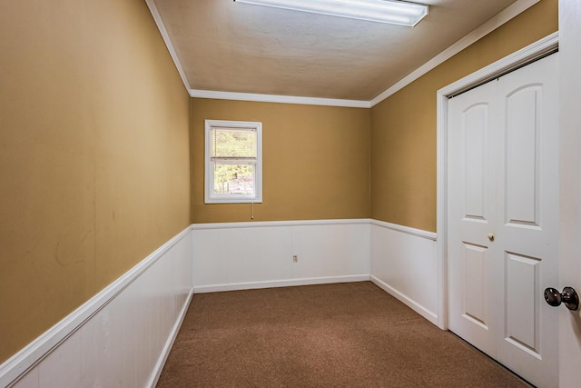 empty room with crown molding and carpet floors