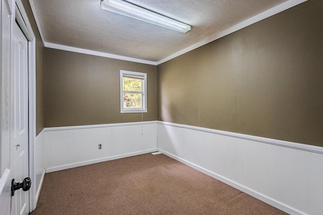 carpeted empty room featuring crown molding