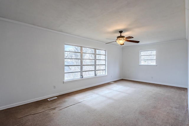 empty room with ornamental molding, carpet floors, and ceiling fan