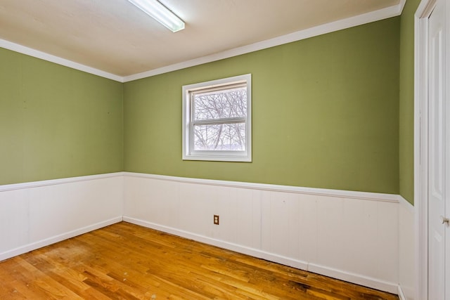 spare room featuring wood-type flooring and crown molding