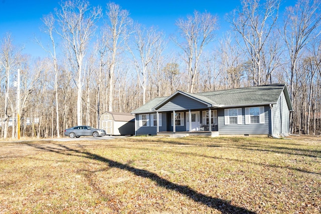 view of front of house featuring a front lawn, covered porch, and a storage unit