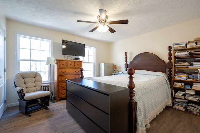 bedroom featuring ceiling fan, dark hardwood / wood-style floors, and a textured ceiling