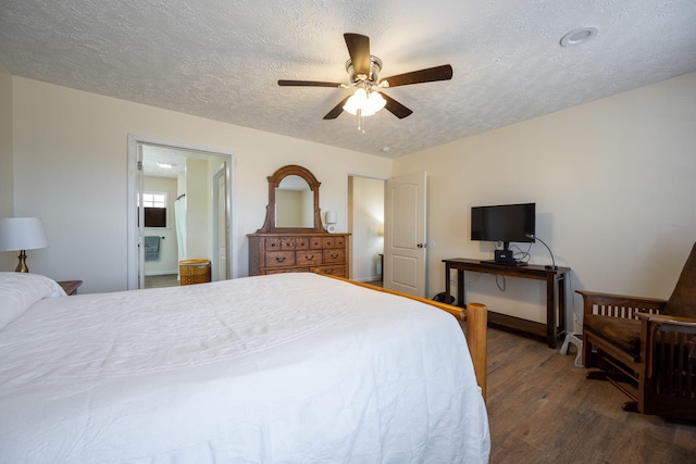 bedroom with a textured ceiling, ceiling fan, dark hardwood / wood-style floors, and ensuite bathroom