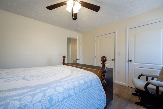 bedroom featuring ceiling fan, dark hardwood / wood-style flooring, a textured ceiling, and two closets