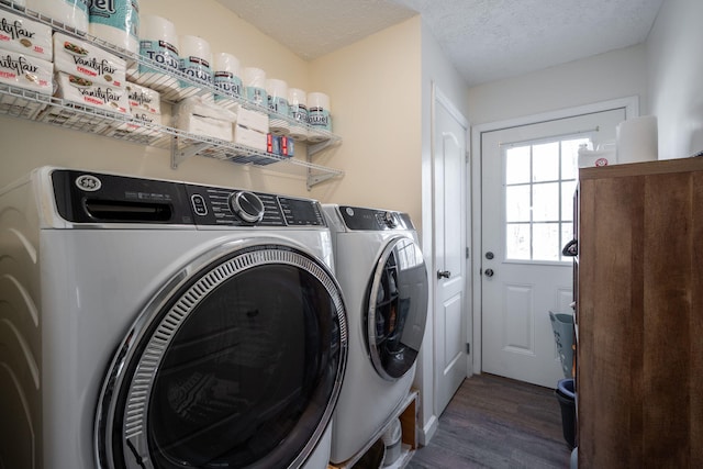 washroom with washer and dryer, a textured ceiling, and dark hardwood / wood-style floors