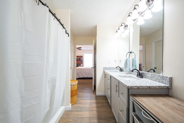 bathroom with vanity, wood-type flooring, a textured ceiling, and a shower with shower curtain