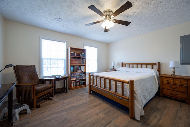 bedroom featuring a textured ceiling, dark hardwood / wood-style floors, and ceiling fan