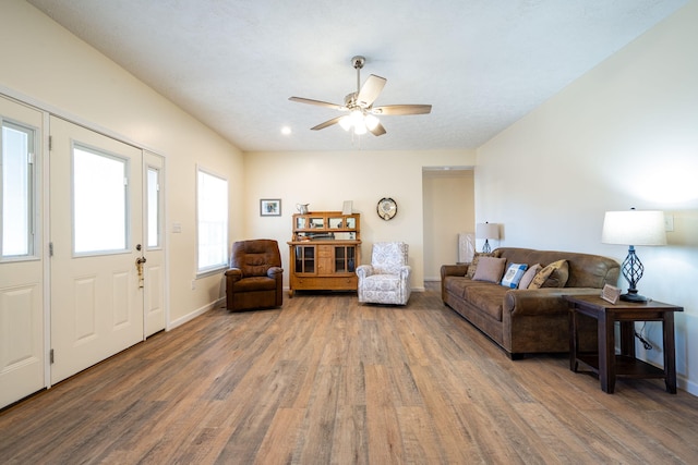 living room with ceiling fan and dark wood-type flooring