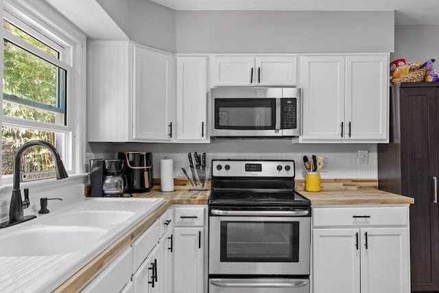 kitchen featuring sink, white cabinets, and appliances with stainless steel finishes