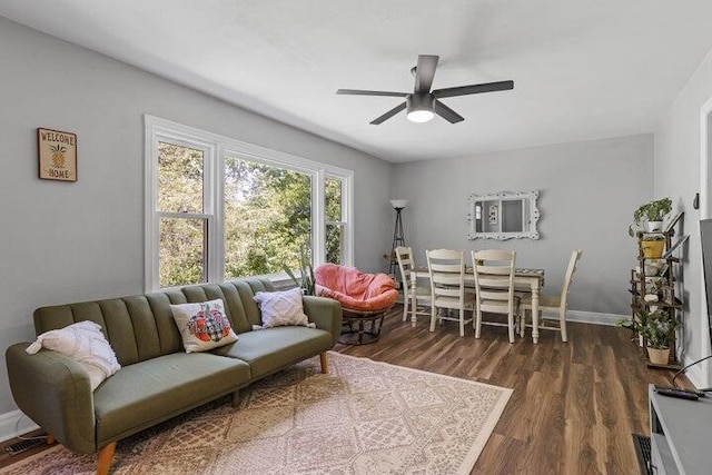 living room with dark hardwood / wood-style flooring and ceiling fan