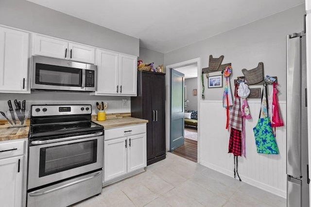 kitchen featuring white cabinetry, light tile patterned floors, and appliances with stainless steel finishes