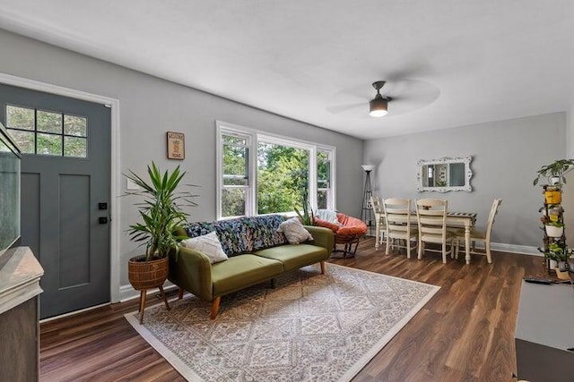 living room featuring dark wood-type flooring, ceiling fan, and a healthy amount of sunlight