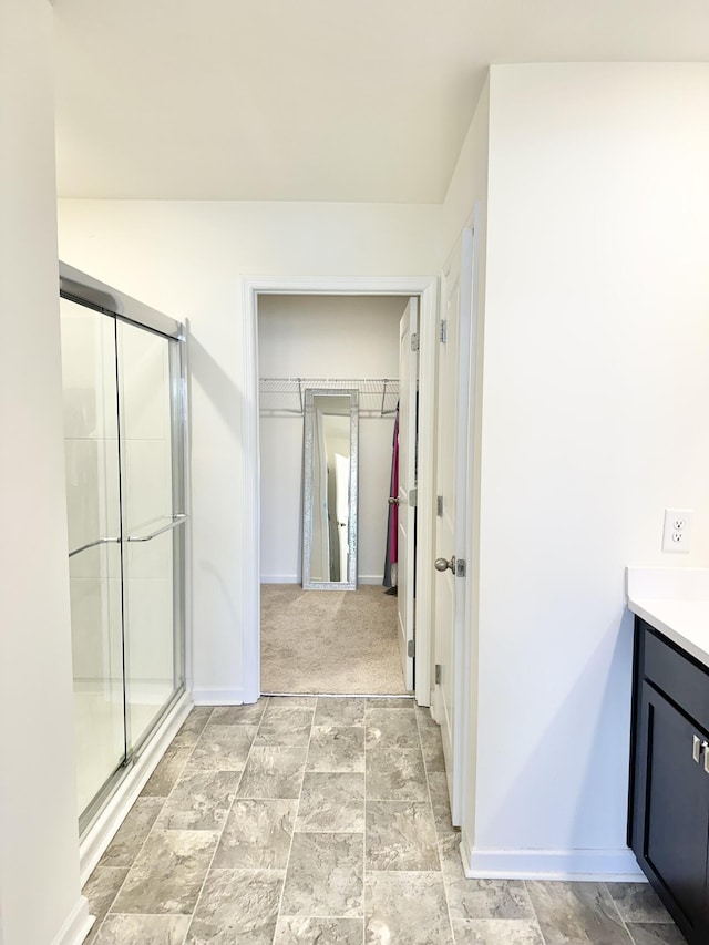 119 Lindsell Rd, Athens, TN 37303 - full bathroom with baseboards, stone finish floor, a shower stall, vanity, and a walk in closet