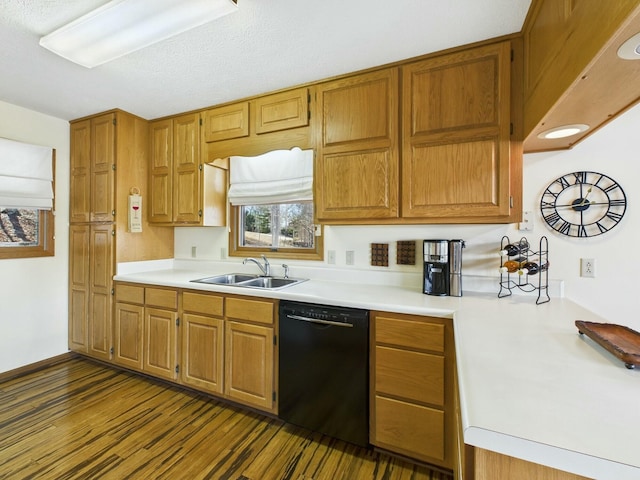 kitchen with black dishwasher, brown cabinetry, dark wood-type flooring, light countertops, and a sink