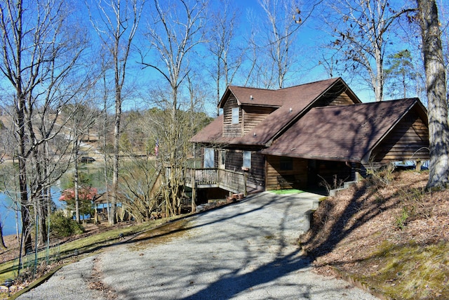 view of property exterior with aphalt driveway and a porch