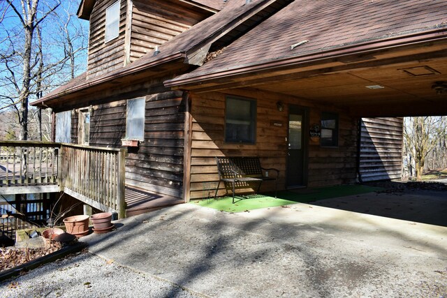 view of exterior entry with a shingled roof