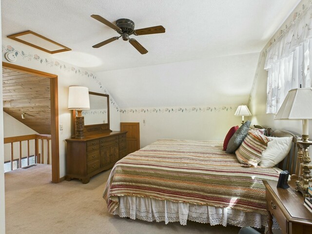 bedroom featuring a ceiling fan, light colored carpet, and vaulted ceiling