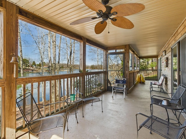 sunroom / solarium with a water view and ceiling fan