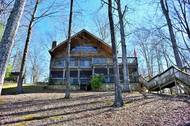 back of property with stairway, a chimney, and a balcony