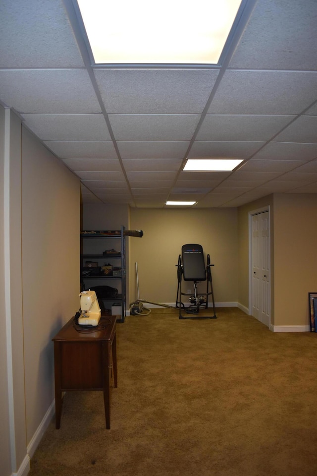 interior space featuring a drop ceiling, baseboards, and carpet