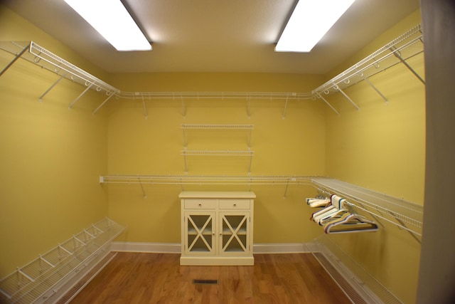 walk in closet featuring visible vents and wood finished floors