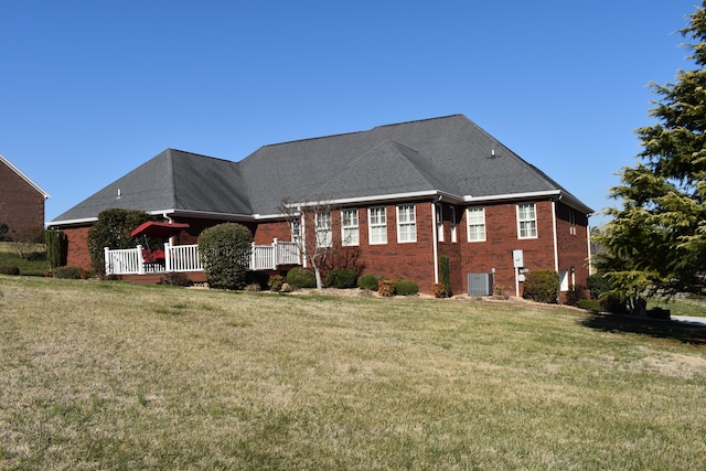 back of house featuring brick siding, central air condition unit, a yard, and a deck