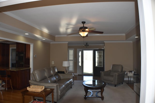 living area featuring light wood-type flooring, ceiling fan, and ornamental molding