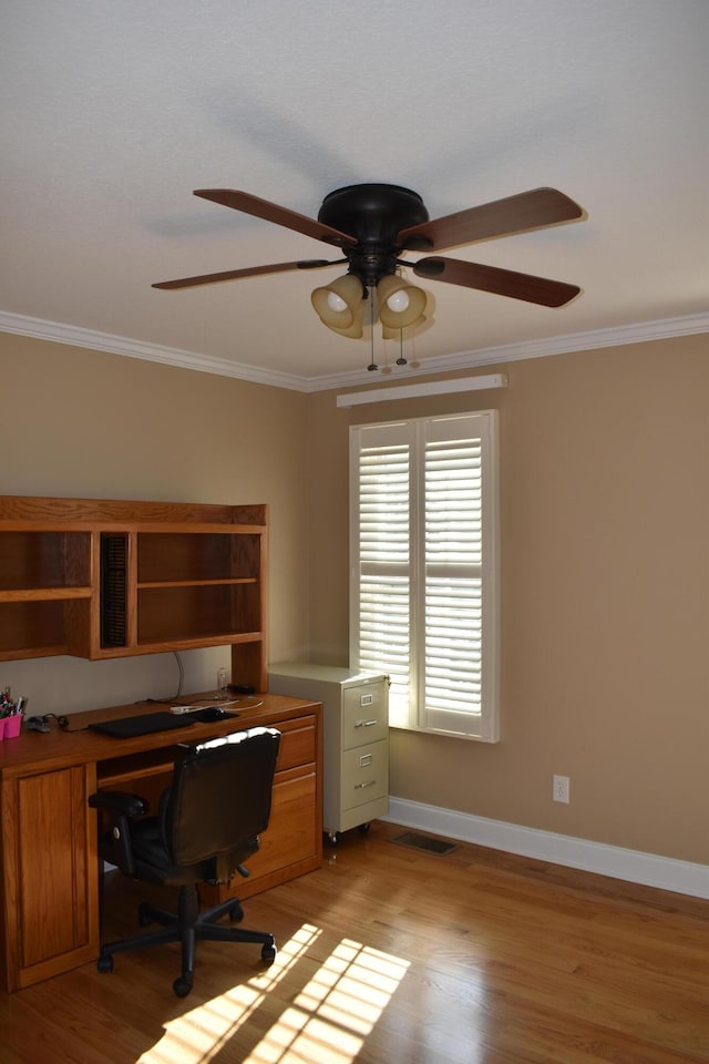 home office with ceiling fan, light wood-style flooring, baseboards, and ornamental molding