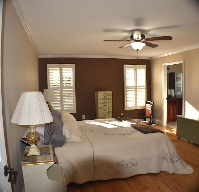 bedroom featuring a ceiling fan, wood finished floors, and crown molding