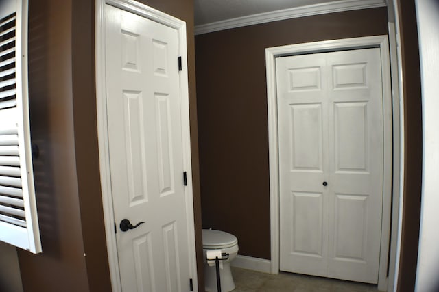 bathroom featuring toilet, baseboards, and ornamental molding