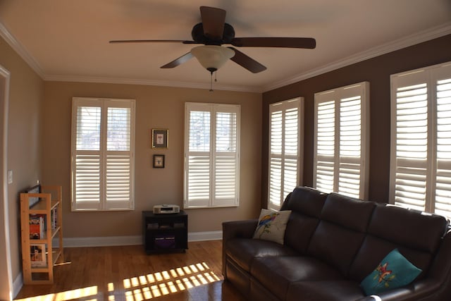 living room with ceiling fan, baseboards, wood finished floors, and ornamental molding