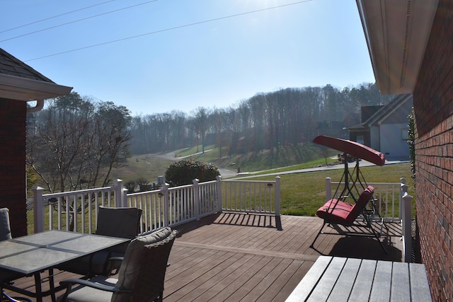 deck with outdoor dining space and a yard