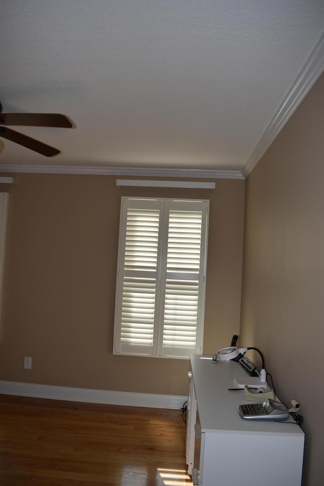 office space featuring crown molding, wood finished floors, baseboards, and ceiling fan