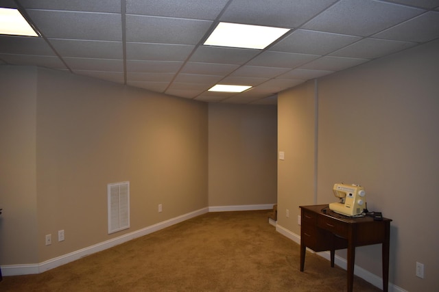 basement featuring visible vents, a paneled ceiling, baseboards, and carpet floors