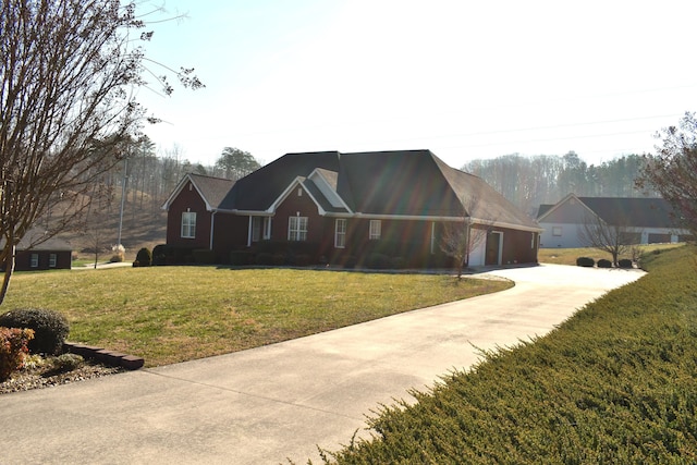 view of front of house with a front yard, an attached garage, and driveway