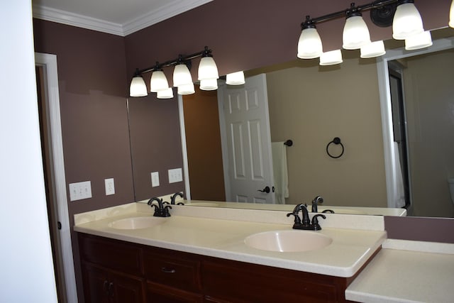 bathroom featuring crown molding, double vanity, and a sink