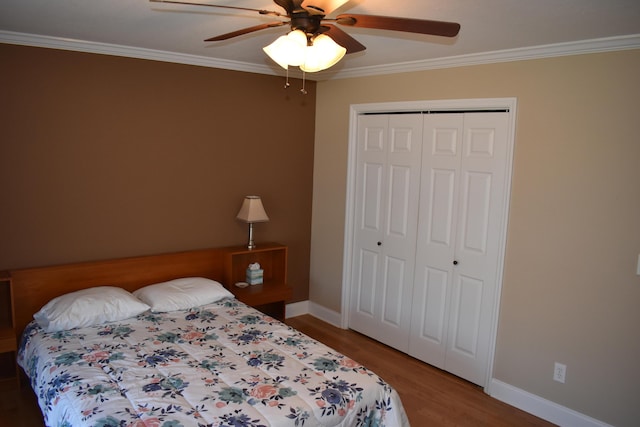 bedroom featuring a closet, wood finished floors, ceiling fan, and ornamental molding