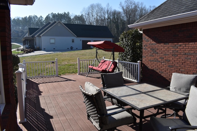 deck with a lawn and outdoor dining area