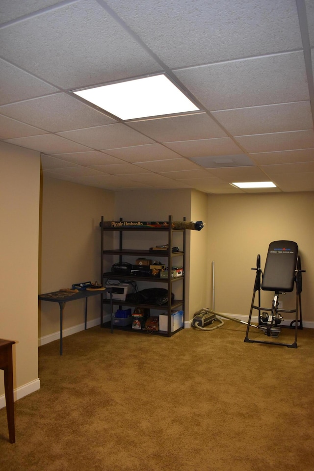 interior space with carpet, baseboards, and a drop ceiling