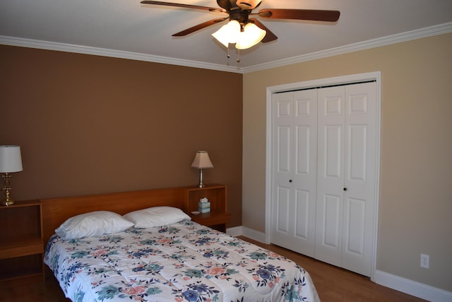 bedroom featuring wood finished floors, a ceiling fan, baseboards, a closet, and crown molding