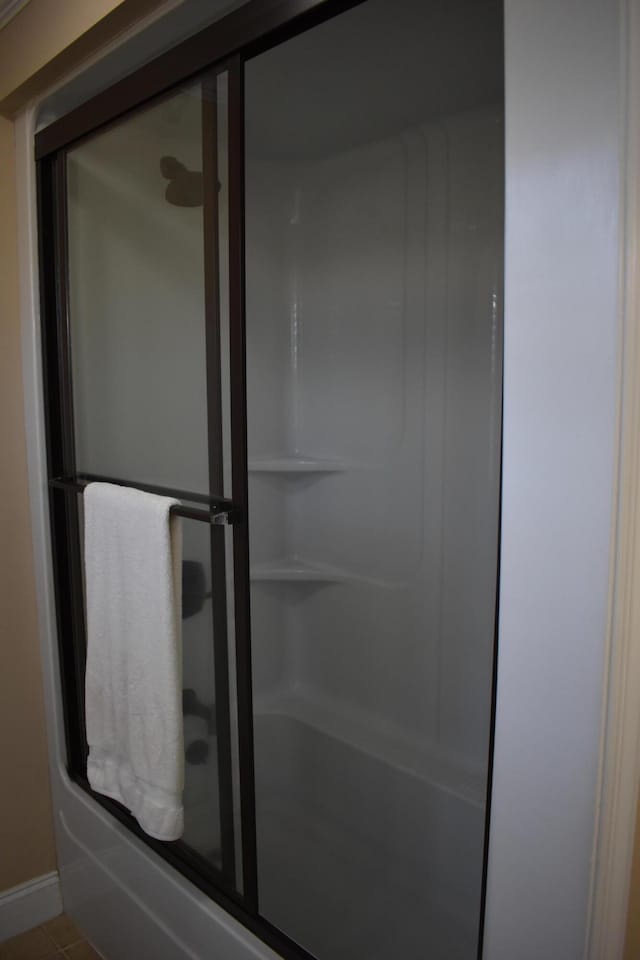 bathroom featuring a shower with door, tile patterned floors, and baseboards