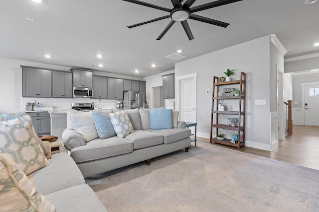 living room featuring ceiling fan and light hardwood / wood-style flooring