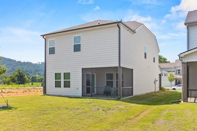 rear view of house with a sunroom and a yard