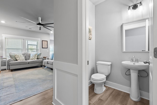 bathroom with hardwood / wood-style floors, toilet, ceiling fan, and sink