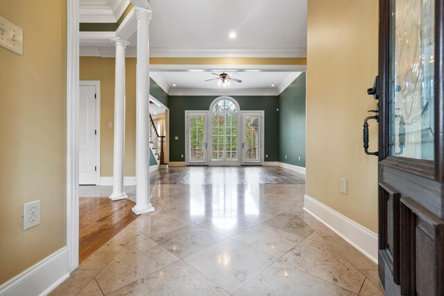 foyer entrance featuring decorative columns, crown molding, ceiling fan, and light wood-type flooring