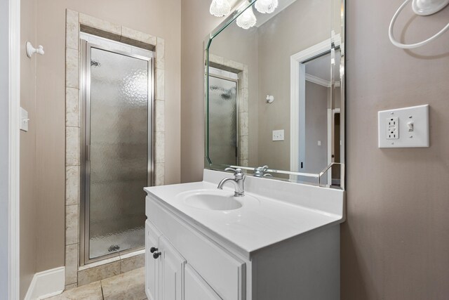 bathroom featuring tile patterned floors, vanity, ornamental molding, and a shower with door