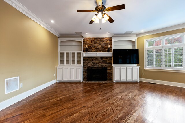 unfurnished living room with a fireplace, crown molding, ceiling fan, and dark wood-type flooring