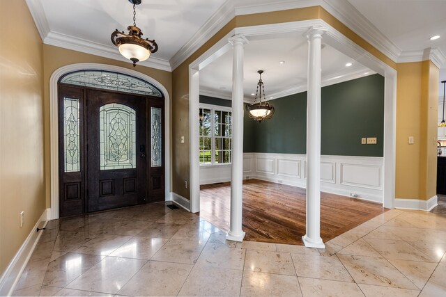 entrance foyer with decorative columns, light hardwood / wood-style flooring, and ornamental molding