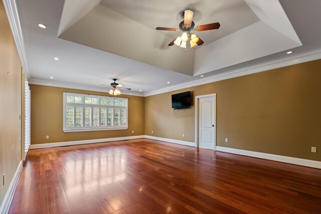 spare room with hardwood / wood-style floors, ceiling fan, a raised ceiling, and ornamental molding