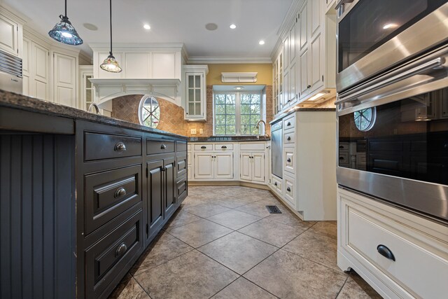 kitchen featuring backsplash, ornamental molding, light tile patterned floors, white cabinetry, and hanging light fixtures